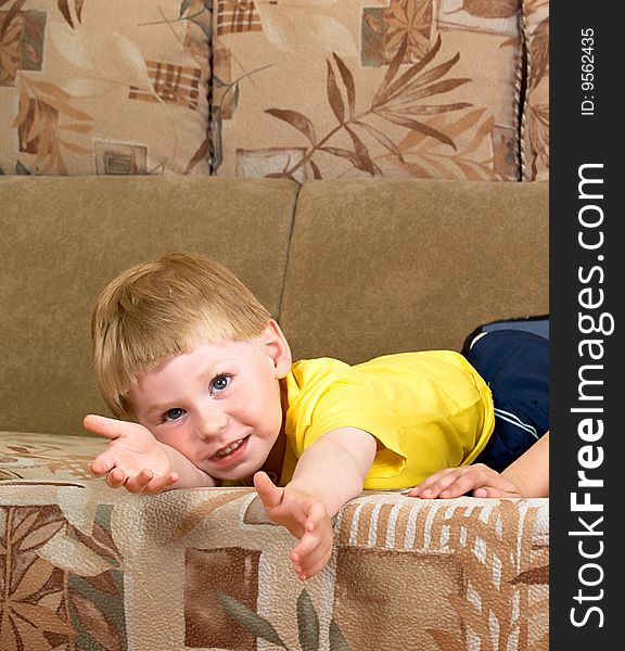 The little boy lays on a sofa of the house. The little boy lays on a sofa of the house