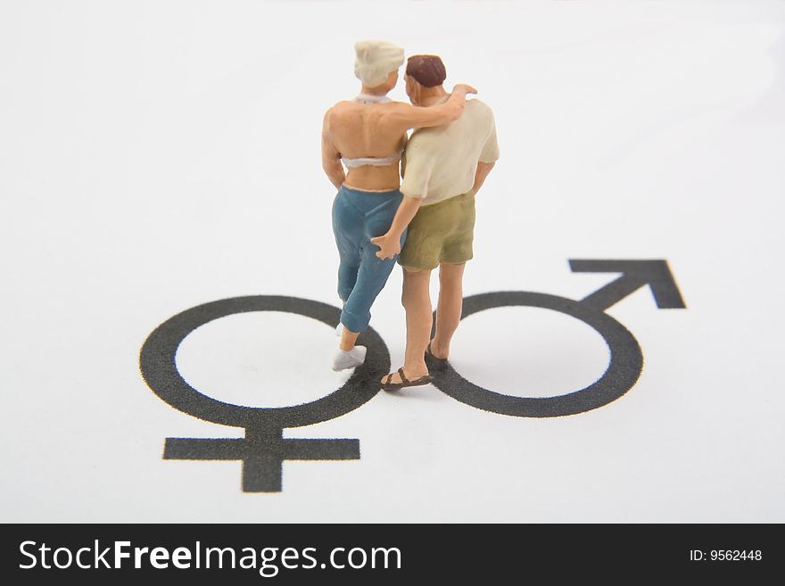 Miniature man and woman on male and female symbols