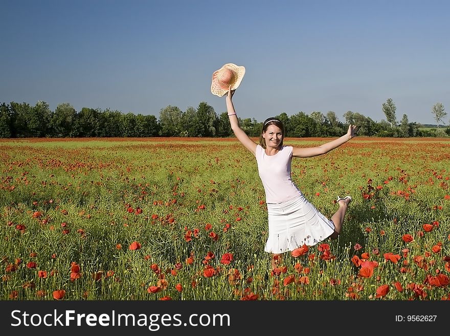 A beautiful woman feels happy on the poppy field. A beautiful woman feels happy on the poppy field.