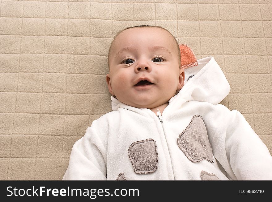 Beautiful baby boy smiling on bed. Beautiful baby boy smiling on bed.