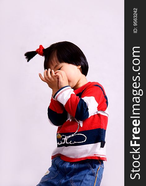 Picture of a little chinese girl with pigtail hiding face with hands