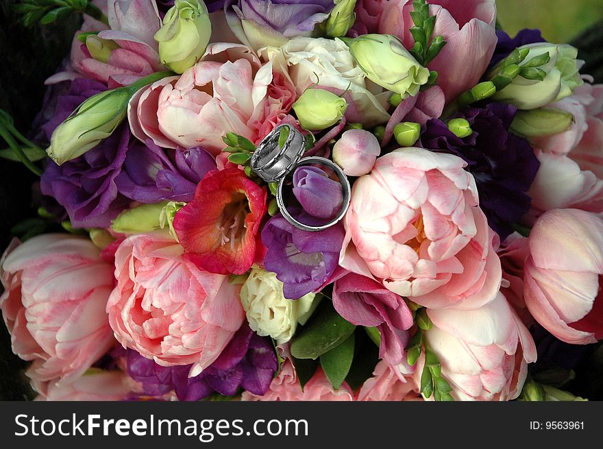 Wedding bunch made from different flowers with rings on the peak