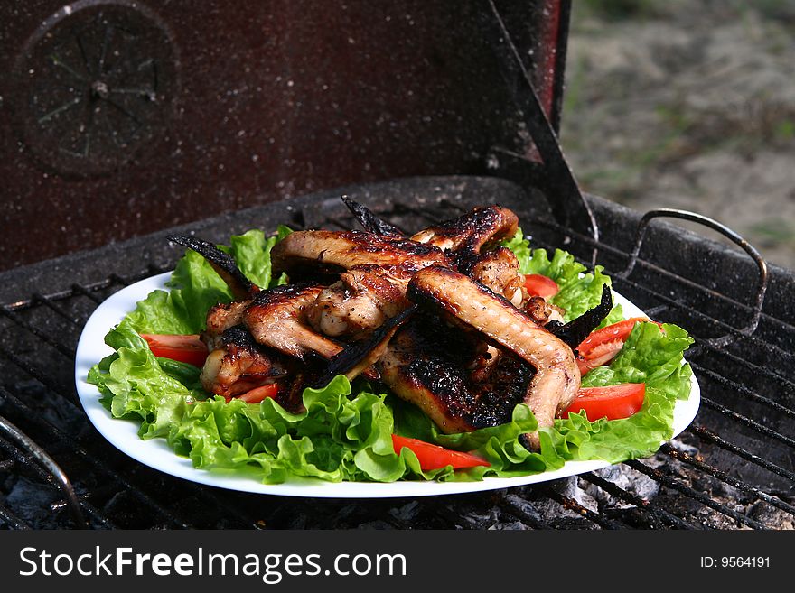 Chicken legs on the grill with vegetables