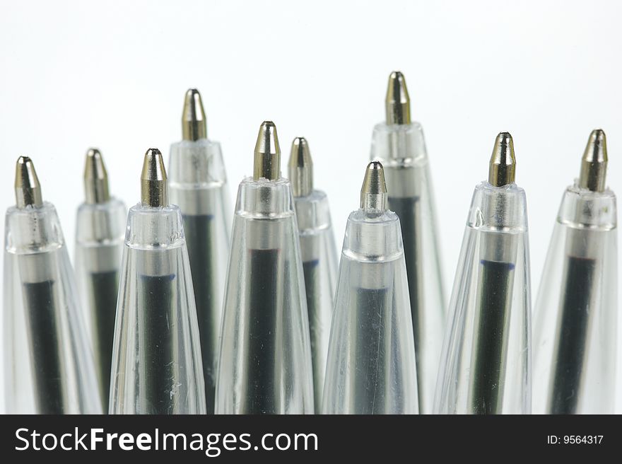 Ball point pens in a cup holder isolated against a white background