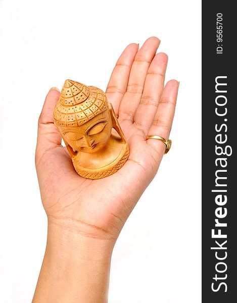 Female hand with wooden carving of buddha face isolated on white background. Female hand with wooden carving of buddha face isolated on white background