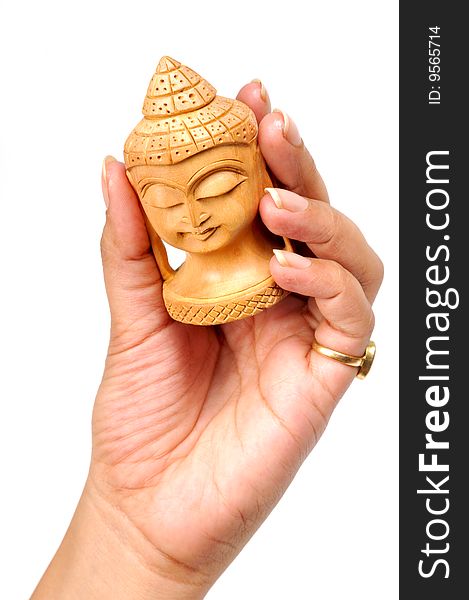 Wooden buddha face in femal's hand isolated on white background.