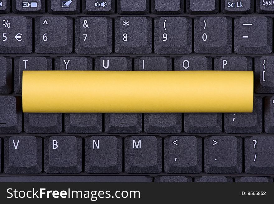 Yellow Rolling Note on a notebook keyboard. Yellow Rolling Note on a notebook keyboard