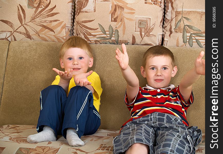 Portrait of two boys laying on a sofa of the house