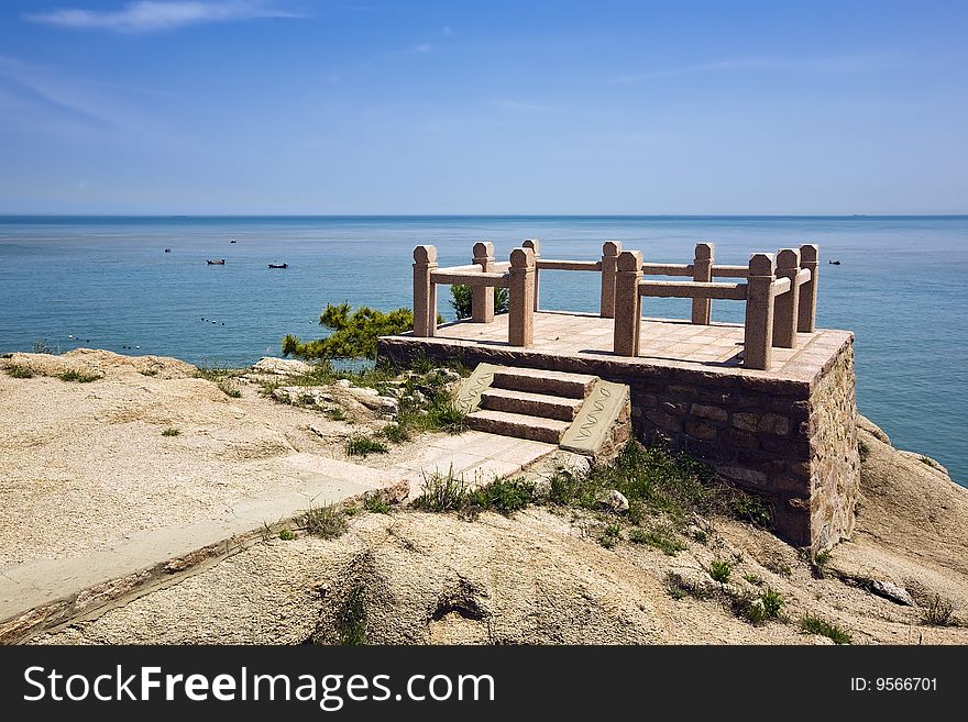 A circular rock lookout point overlooking the sea.