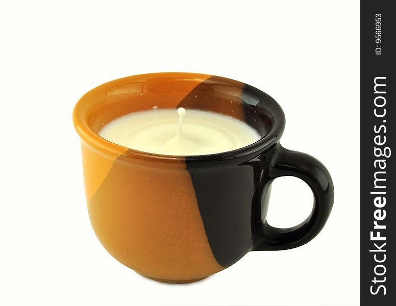 Milk in a brown ceramic cup with a falling drop