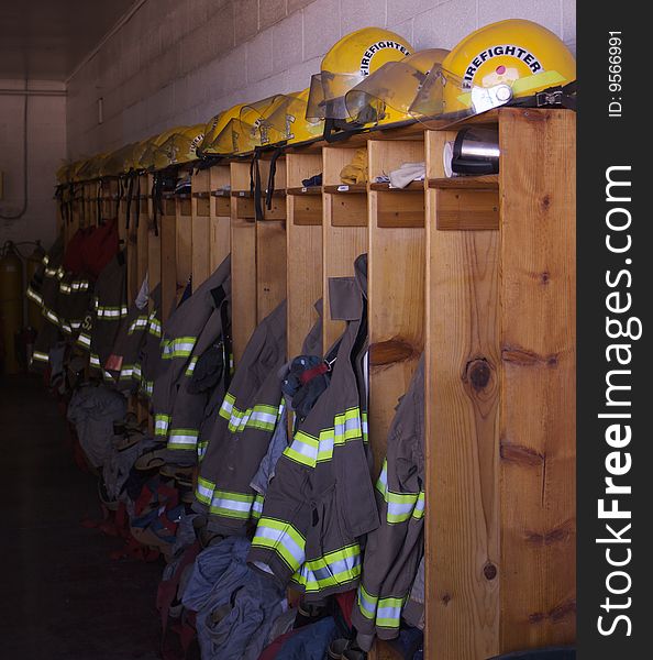 A row of lockers in a firehouse with jackets and helmets. A row of lockers in a firehouse with jackets and helmets