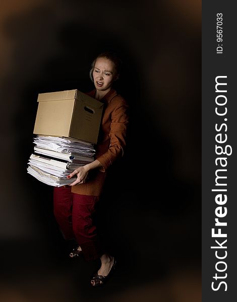 Young frustrated businesswoman with paper box - dark background