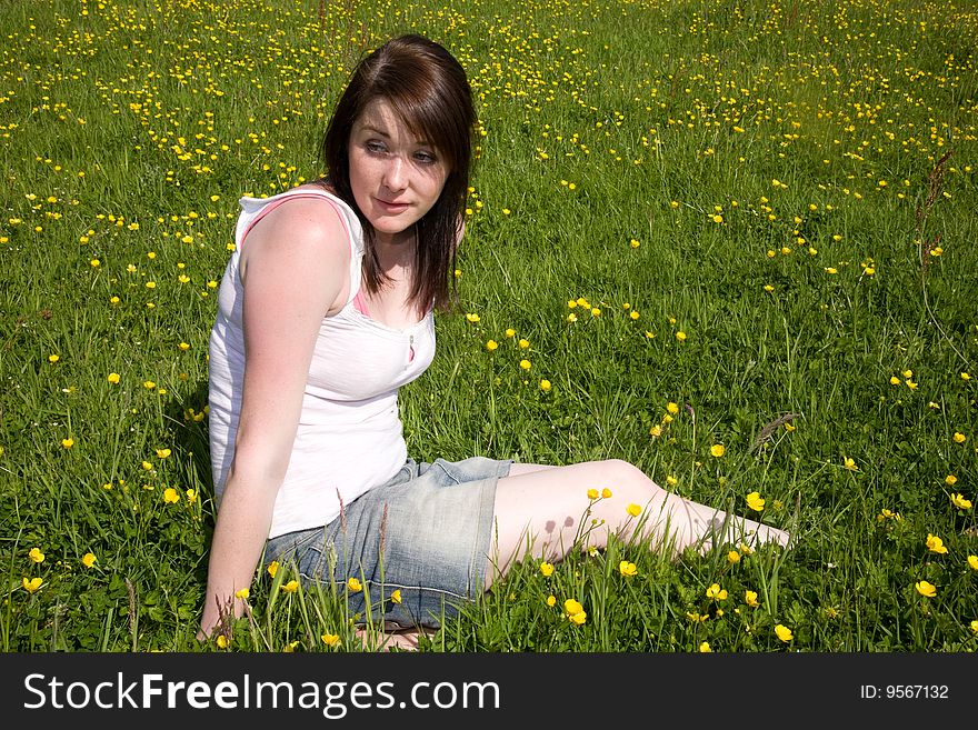 A woman sitting in a field. A woman sitting in a field