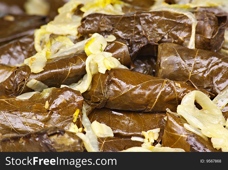 Full shot of stuffed Grape leaves with sauteed onions that fill the image. Full shot of stuffed Grape leaves with sauteed onions that fill the image.