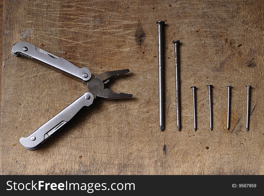 Flat-nose pliers and nails on a table