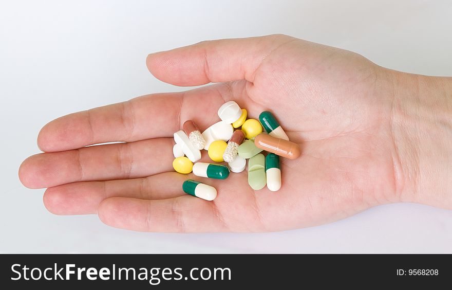 Hand with group of pills and capsules