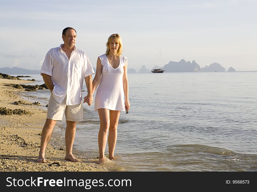 Couple holding hands and walking on the beach. Couple holding hands and walking on the beach