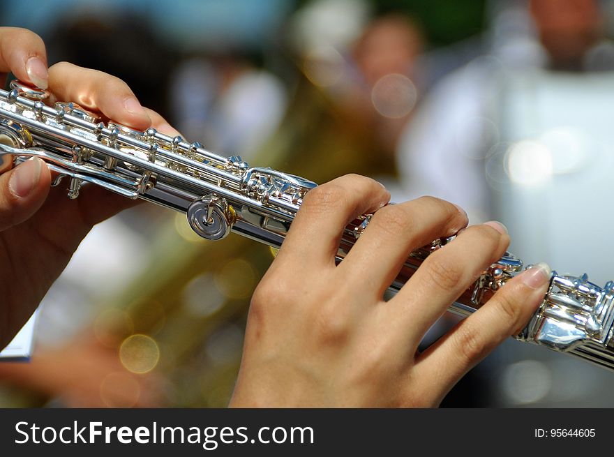 Close up of hands of woman playing flute.