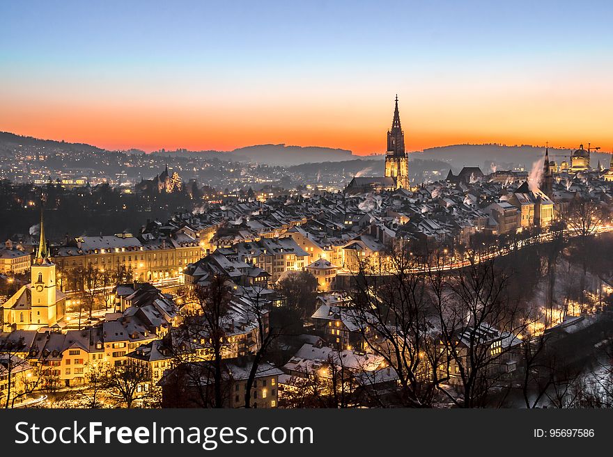 Aerial view of city with castle and church illuminated at sunset. Aerial view of city with castle and church illuminated at sunset.