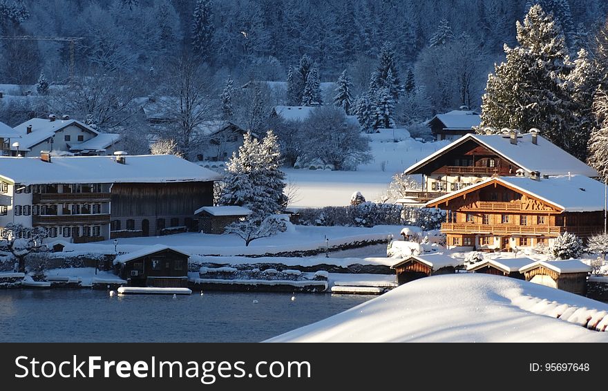 Houses covered in snow on the lake coast in winter. Houses covered in snow on the lake coast in winter.