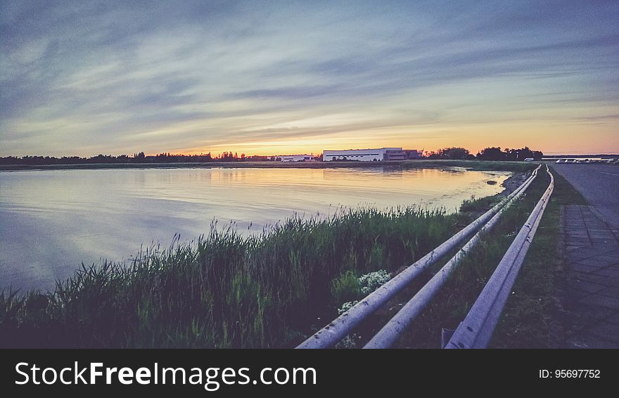 Highway past lake at sunset