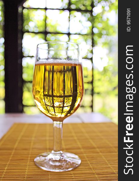Glass of golden beer on the table on nature background