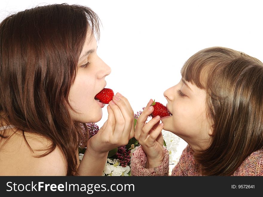 Two little girls eating a strawberries