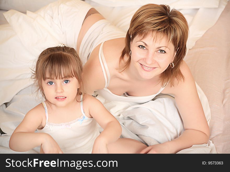 Portrait of a happy mother with her daughter in a bedroom. Portrait of a happy mother with her daughter in a bedroom.