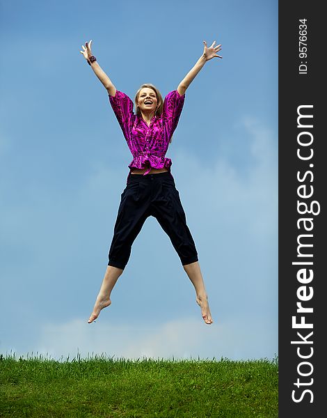 Pretty girl jumping over green grass