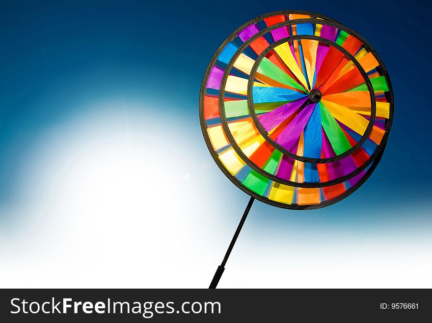 Plastic colourful pinwheel on the blue and white background