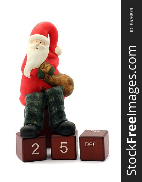 Santa Clause figurine standing on calendar cubes