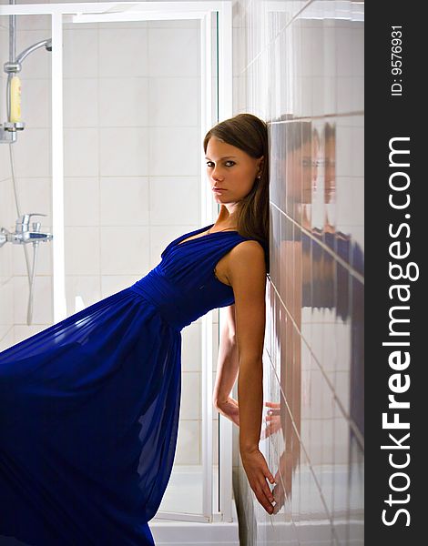 Young woman in bathroom. Blue dress. Young woman in bathroom. Blue dress