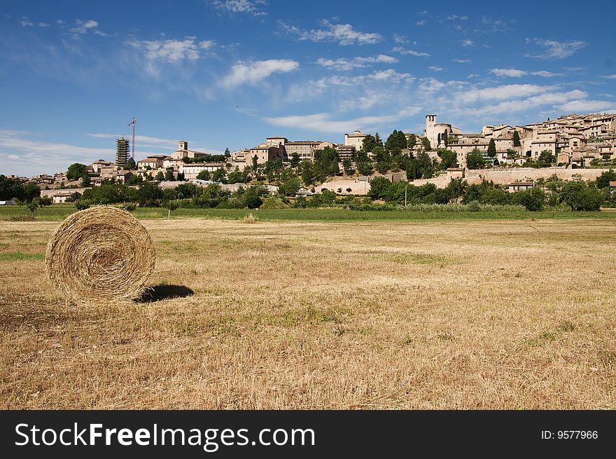 Photo of Spello with hay bale and blue sky in the summer
