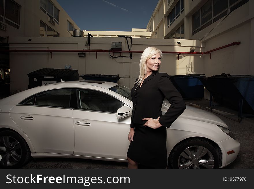 Successful businesswoman smiling and standing next to her luxury car