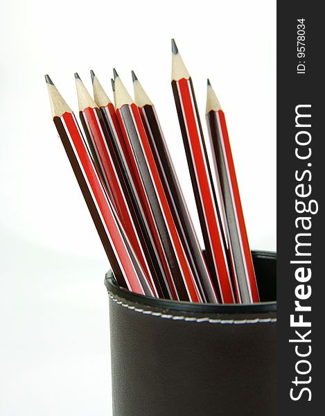 Lead pencils in a cup holder isolated against a white background. Lead pencils in a cup holder isolated against a white background