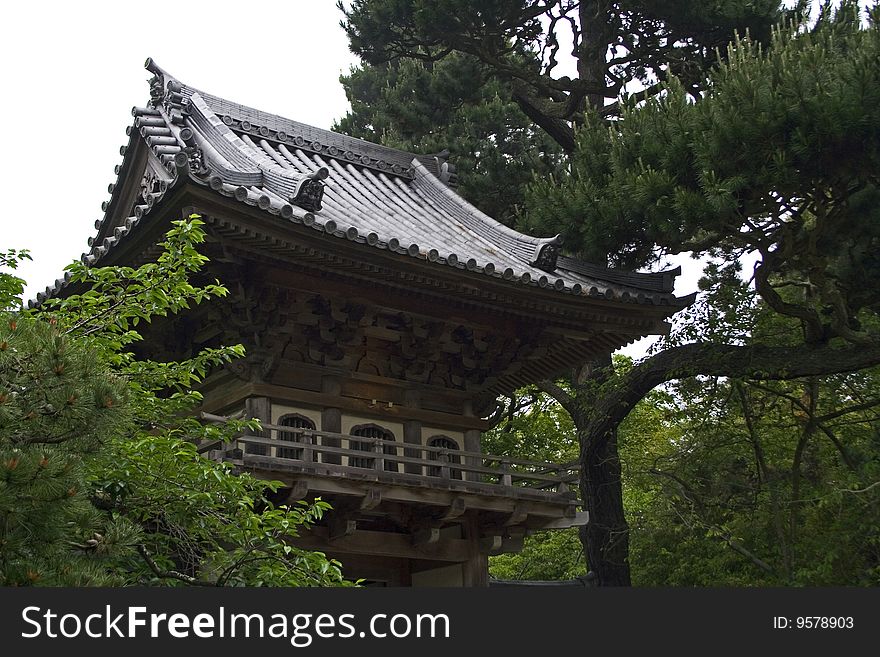 Oriental house in japanese garden through the trees