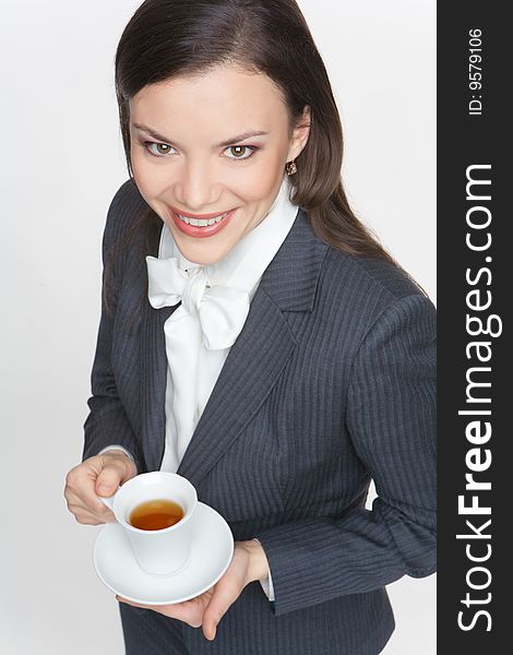 The woman in a business suit holds a cup with tea