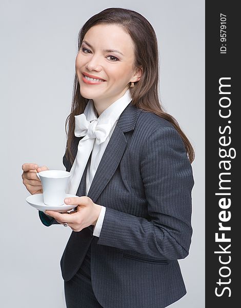 The woman in a business suit holds a cup