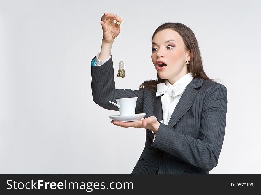 The woman in a business suit holds a cup with tea