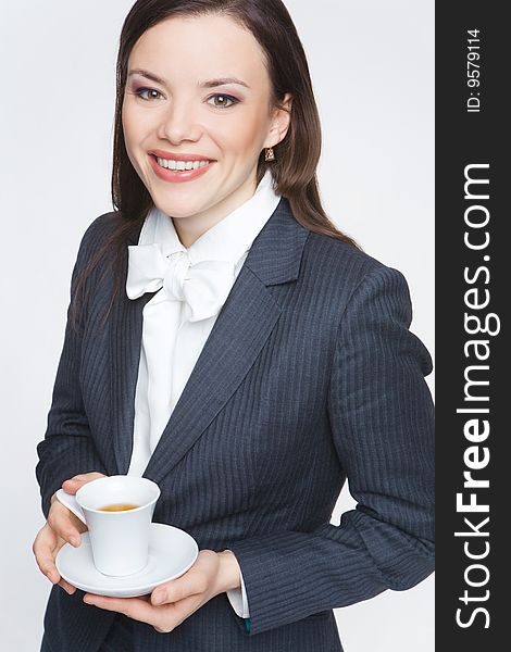 The woman in a business suit holds a cup with tea