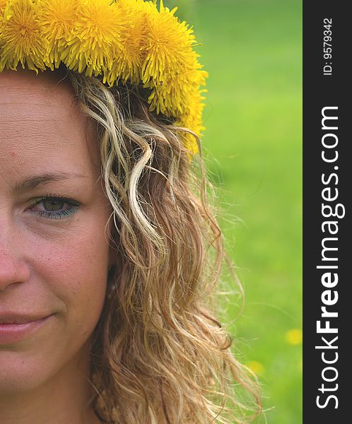 Curly girl portrait with dandelion chain on head