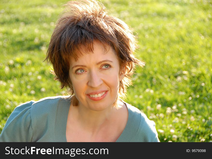 Woman sitting on green grass looking up to sky with good feeling. Woman sitting on green grass looking up to sky with good feeling