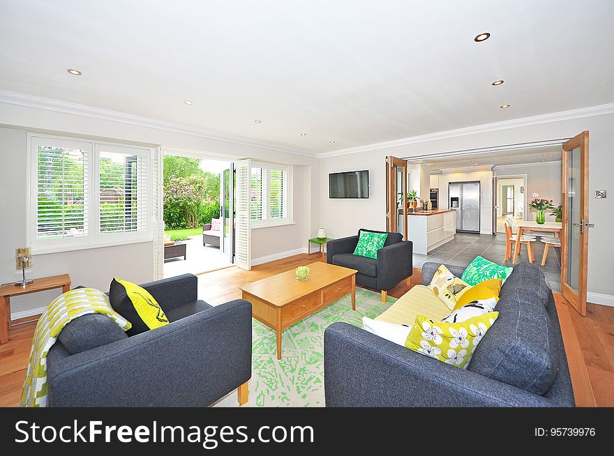 Bright cheerful sitting room (lounge) of modern open plan home showing three piece leather suite, picture window to the garden and through open glass doors a fully fitted kitchen and dining table. Bright cheerful sitting room (lounge) of modern open plan home showing three piece leather suite, picture window to the garden and through open glass doors a fully fitted kitchen and dining table.