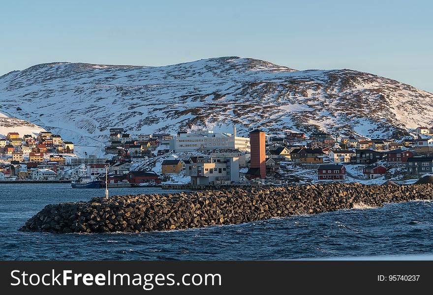 A rocky dock and a coastal town in winter. A rocky dock and a coastal town in winter.