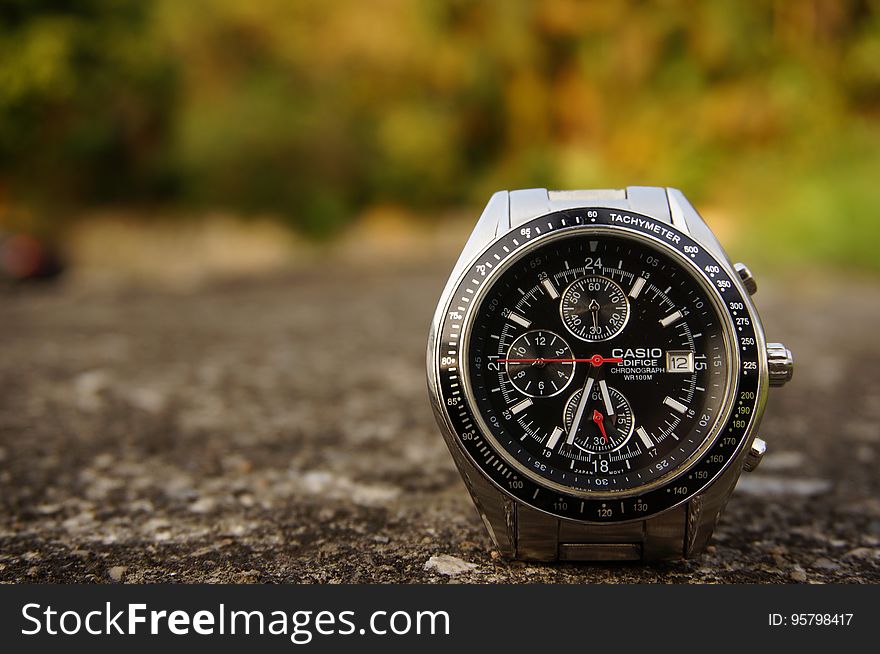 Closeup of sophisticated Casio wrist watch with multiple features on a path with a background of colorful Autumn leaves. Closeup of sophisticated Casio wrist watch with multiple features on a path with a background of colorful Autumn leaves.