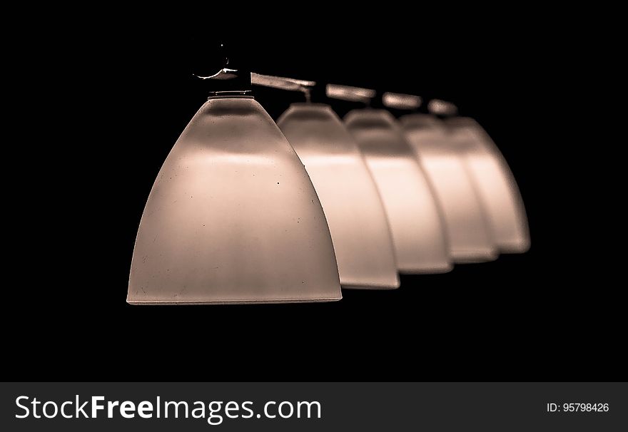 A row of frosted glass lamp shades. A row of frosted glass lamp shades.