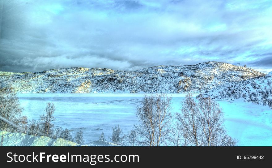 A panoramic view of a frozen mountain lake.