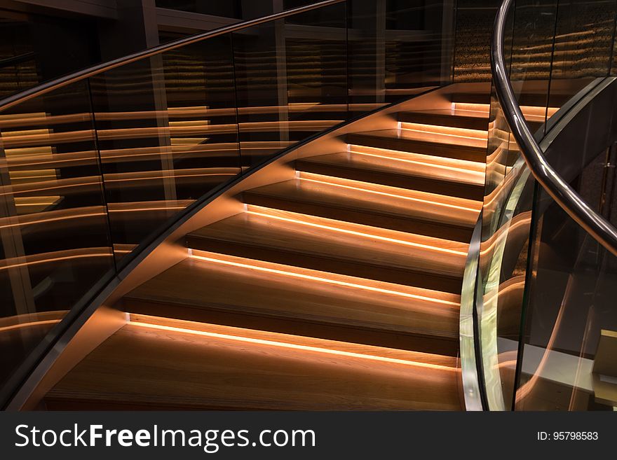 An illuminated staircase surrounded by glass railings.