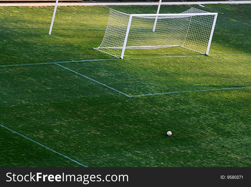 Empty goal post with ball infront on a football pitch