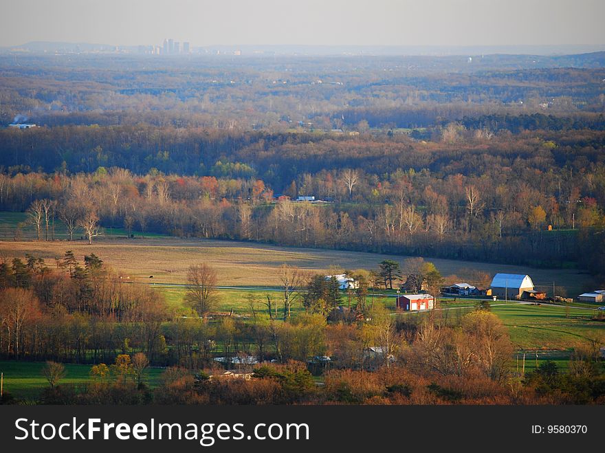 View of rural farm with city in background. View of rural farm with city in background